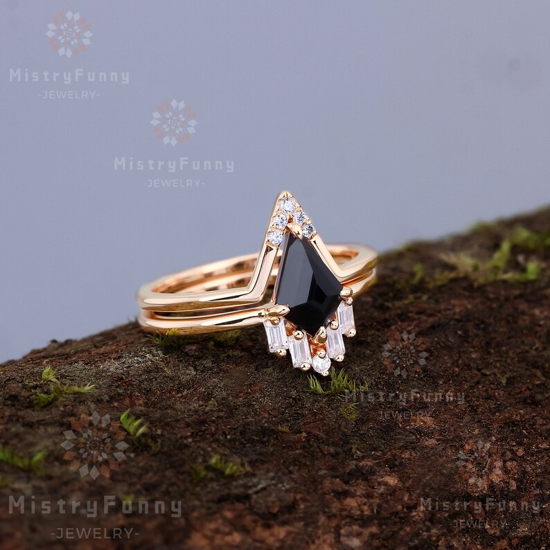 May include: A gold ring set with a black gemstone and smaller white gemstones. The ring is set on a wooden surface.