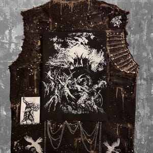 May include: A distressed brown vest with multiple patches and metal accents. The back features a large black and white graphic of a chaotic scene, with smaller patches and chain details. The vest has a grunge aesthetic.