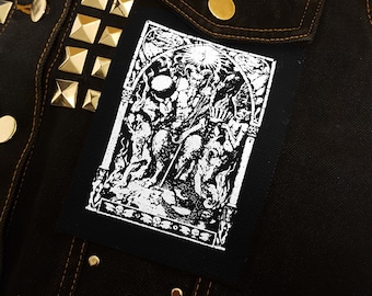 May include: Black and white patch featuring a detailed illustration of a figure with a crown and a staff, surrounded by other figures. The patch is sewn onto a black denim jacket with gold studs.
