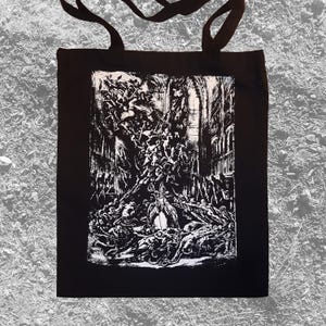 May include: Black tote bag with a white graphic print of a detailed illustration of a scene with many figures. The illustration is in a dark, gothic style.