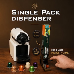 Könnte beinhalten: Eine weiße Kaffeemaschine und ein Einzelpackungsspender sind abgebildet. Der Spender enthält eine Schachtel mit Starbucks-Kaffeepads. Der Text "SINGLE PACK DISPENSER" und "FOR A MORE PRODUCTIVE DAY" ist enthalten.