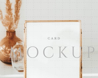 Może przedstawiać: Złota rama z białą kartką w środku. Na kartce widnieje tekst "CARD MOCKUP" oraz symbol praw autorskich, po którym następuje "CELEBRATE YOUR PARTY".