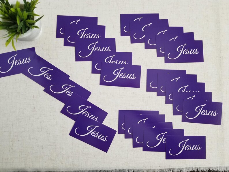Jesus gospel tracts — Acts 4:12 Christian scripture cards with salvation prayer; multiple purple “Jesus” fronts scattered on linen surface with small plant décor; 25-pack (25–250 options).
