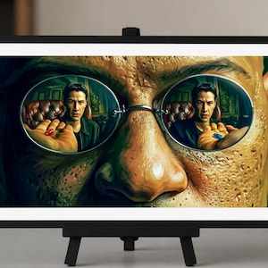 May include: A framed rectangular print on a black easel featuring a close-up of a face wearing round glasses. The lenses reflect a person sitting in a leather chair, with one hand holding a red pill and the other hand holding a blue pill.
