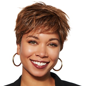 Può includere: Una donna con i capelli corti castani sorride e indossa un blazer nero. Indossa grandi orecchini a cerchio dorati.