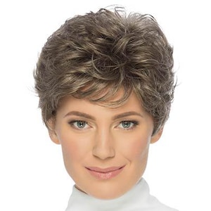 Może przedstawiać: Kobieta w krótkiej, warstwowej peruce z mieszanką jasnobrązowych i szarych odcieni. Peruka ma naturalny wygląd z miękkimi falami i przedziałkiem z boku. Ma na sobie białą koszulę z golfem.