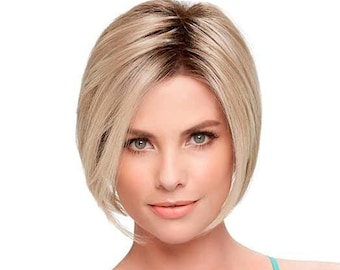 Puede incluir: Una mujer con el pelo corto, liso y rubio con una raíz marrón claro. Lleva un top turquesa de tirantes con un patrón de encaje.