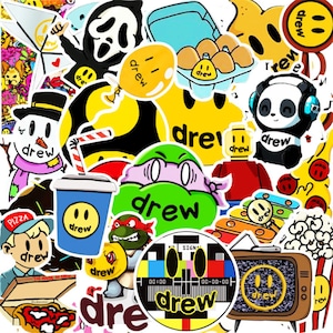 May include: A collection of colourful stickers featuring the word "Drew" and various cartoon characters, including a ghost, a panda, a snowman, and a Teenage Mutant Ninja Turtle. The stickers are on a white background.