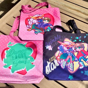 May include: Three pink and black tote bags with different designs. The first bag has a green heart with the text "Damon I Love You!" The second bag has a pink heart with a cartoon couple. The third bag has a black background with stars and a cartoon couple with the text "Twinkle Twinkle Little Star".