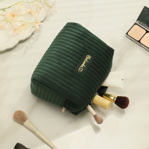 a green cosmetic bag sitting on top of a table