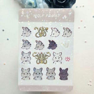 May include: A sheet of holographic stickers featuring a wolf family with the text "Wolf Family". The stickers are white, grey, and black with a holographic finish. The stickers are arranged in a grid pattern.