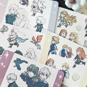 以下が含まれることがあります： 様々なポーズの漫画のキャラクターが描かれたイラストステッカーのコレクション。ステッカーは、パステルカラーのボーダーと星のアクセントが付いた白い背景です。キャラクターは、詳細な服装と髪型で描かれています。