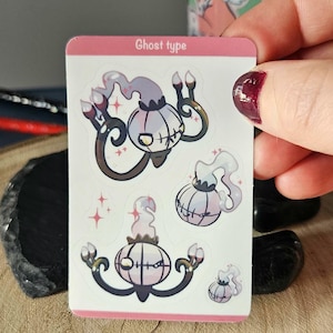 Può includere: Un foglio di adesivi con illustrazioni a tema fantasma. Gli adesivi presentano un design in stile cartone animato con una tavolozza di colori bianca, viola e nera. Il testo "Ghost type" è in alto.