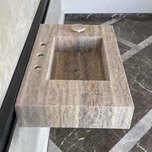 May include: A rustic wooden sign with the text "Welcome to our home" in white lettering. The sign features a distressed finish and a simple, inviting design, perfect for a front porch or entryway.