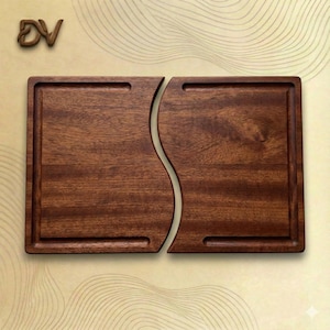 May include: Two-piece wooden serving board set. Each board is rectangular with a carved groove and a curved edge that fits together. The wood has a rich, dark brown color and a natural grain pattern. The boards are designed for serving food.