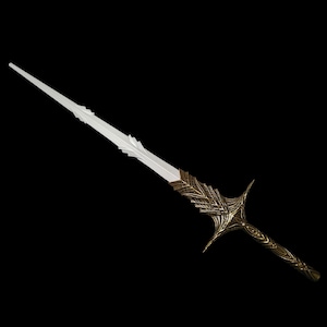May include: A fantasy sword with a white blade and ornate gold-colored hilt. The hilt features intricate leaf-like designs and a crossguard with curved elements. The sword is set against a black background.