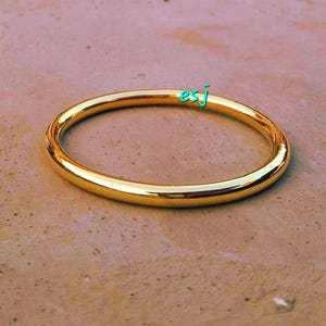 Peut inclure: Un bracelet jonc en or simple. Le bracelet est lisse et brillant.