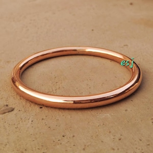 Peut inclure: Un bracelet simple en cuivre. Le bracelet est lisse et brillant, avec une couleur cuivre chaude.