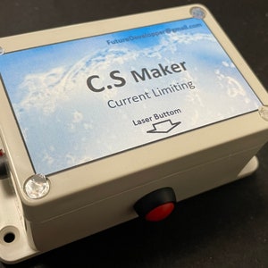 Könnte beinhalten: Eine weiße Plastikbox mit einem blau-weißen Etikett, auf dem "C.S Maker Current Limiting Laser Button" steht. Die Box hat einen roten Knopf an der Seite.