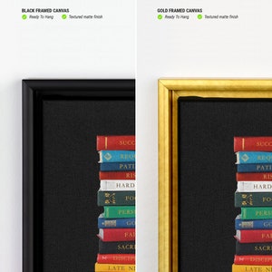 Op de afbeelding: Een zwart ingelijst canvasprint met een stapel boeken met woorden zoals "Succes", "Hard werken", "Discipline" en "Late nachten" gedrukt op de ruggen. Het canvas is textuur en klaar om op te hangen.