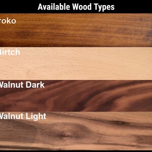 Op de afbeelding: Afbeelding met houtnerfmonsters. De tekst "Available Wood Types" staat bovenaan. De monsters omvatten Iroko, een donkerbruin hout; Birtch, een lichtbeige hout; Walnut Dark, een diep roodbruin hout; en Walnut Light, een lichter bruin hout.