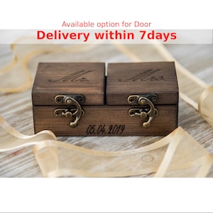 Op de afbeelding: Twee houten ringendozen met scharnierende deksels en messing sluitingen. De dozen zijn gegraveerd met "Mr." en "Mrs." en de datum "05.04.2019".