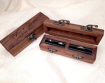 May include: A wooden ring box with a hinged lid and two compartments for rings. The box is engraved with the names "Kylie & Bryan" and the date "04/06/2020".