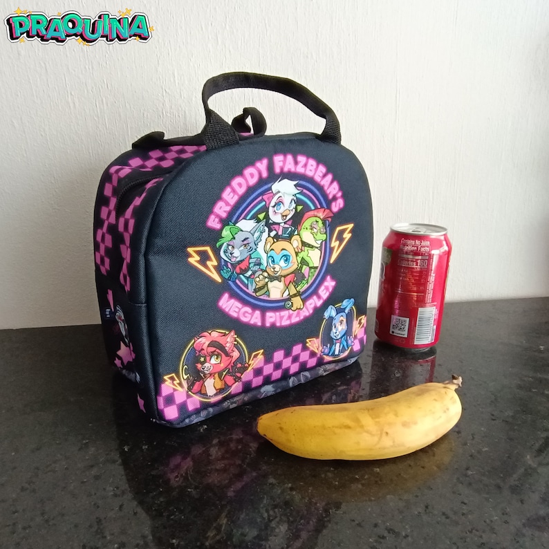 Peut inclure: Sac &agrave; d&eacute;jeuner noir avec un motif &agrave; carreaux rose et blanc. Le sac pr&eacute;sente un graphique de personnages du jeu vid&eacute;o "Freddy Fazbear's Mega Pizzaplex". Le sac a une fermeture &agrave; glissi&egrave;re et une poign&eacute;e sup&eacute;rieure.