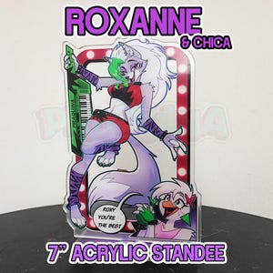 May include: A 7-inch acrylic standee featuring a cartoon character named Roxanne & Chica. Roxanne is a wolf-like character with purple and white fur, wearing a red and black outfit and holding a green keyboard. Chica is a bird-like character with pink feathers and a pink and white outfit. The standee has a red and white background with a spotlight effect.