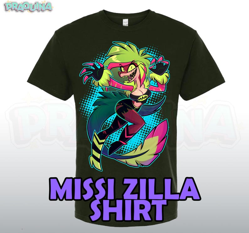 May include: Dark green t-shirt featuring a colorful cartoon illustration of a character with green hair, a red face, and black clothing. The shirt has the text "MISSI ZILLA SHIRT" in purple letters.