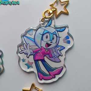 Op de afbeelding: Een transparante acryl sleutelhanger met een cartoonfiguur met blauwe ogen, witte vacht en roze kleding. Het personage heeft vleugels en houdt een pose aan met zijn armen uitgestrekt. De sleutelhanger heeft een gouden sterbedel.