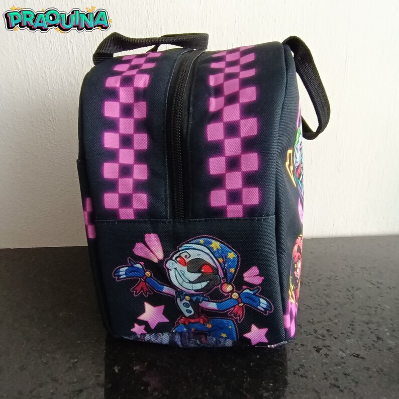 Peut inclure: Sac &agrave; d&eacute;jeuner noir et rose &agrave; carreaux avec un personnage de dessin anim&eacute; sur le devant. Le personnage porte une tenue bleue et jaune et une &eacute;toile sur la t&ecirc;te.