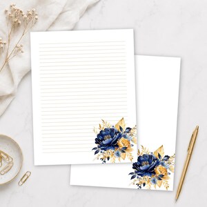 Peut inclure: Deux feuilles de papier à lettres blanc avec de fines lignes horizontales. Chaque feuille présente un arrangement floral dans le coin inférieur droit composé de pivoines bleu marine profond et de feuillage jaune doré.