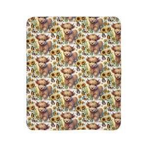 May include: A plush blanket featuring a repeating pattern of Highland cows, sunflowers, and butterflies. The cows are brown with fluffy fur, the sunflowers are yellow, and the butterflies are orange and brown. The background is white.