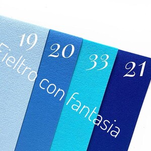 May include: Four felt fabric swatches in shades of blue, labeled with numbers 19, 20, 33, and 21. The text "Feltro con fantasia" is printed on the swatches.