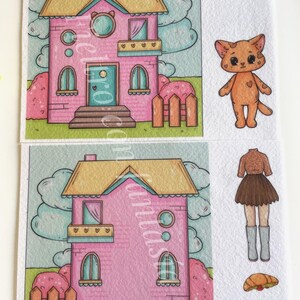 K&ouml;nnte beinhalten: Illustration eines rosa Hauses mit gelbem Dach, einer Katze und Papierpuppenkleidung. Das Haus hat einen herzf&ouml;rmigen Balkon und einen kleinen Zaun. Die Katze ist orange mit einem Herz auf der Brust. Die Kleidung umfasst ein braunes Oberteil, einen Rock, Stiefel und Essen.