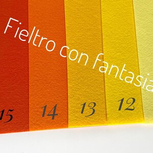 May include: Five strips of felt fabric in various shades of orange and yellow. The felt is labeled with numbers 11, 12, 13, 14, and 15. The text "Felt with fantasy" is written diagonally across the fabric.