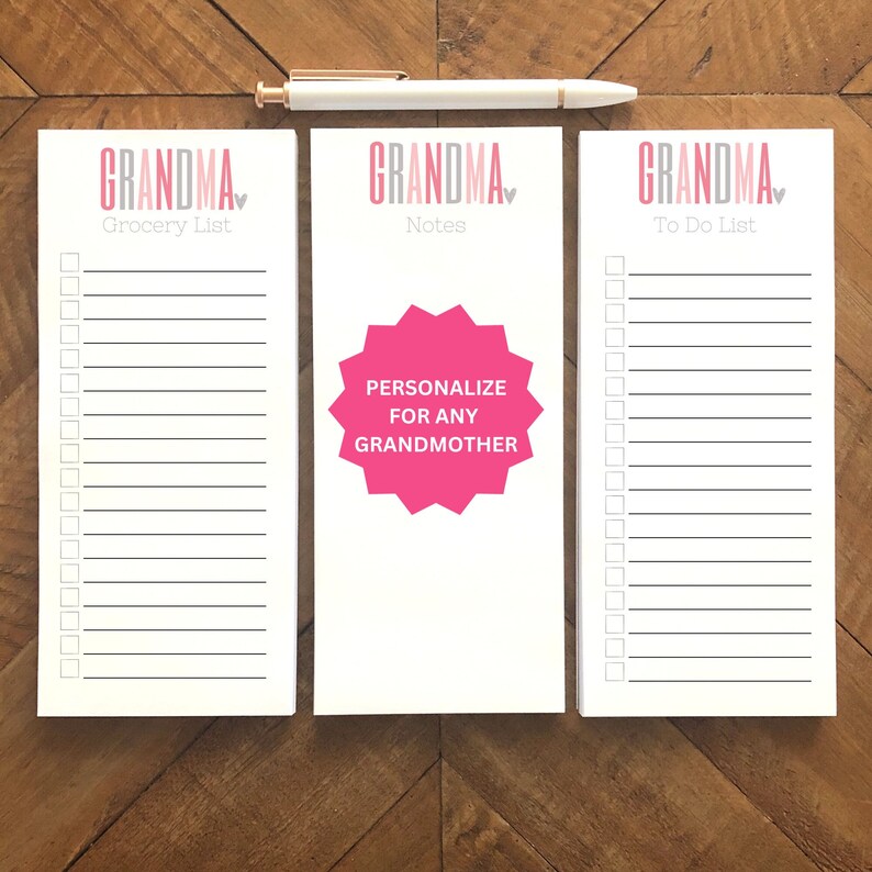 May include: Three white notepads with the word "GRANDMA" in pink and gray, and a pen. One notepad says "Grocery List", another says "Notes" with a pink starburst that says "PERSONALIZE FOR ANY GRANDMOTHER", and the third says "To Do List".