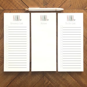 May include: Three white notepad sets with pink and gray text that reads "NANA" with a heart symbol. The notepads are labeled "Grocery List", "Notes", and "To Do List".