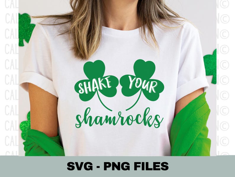 K&ouml;nnte beinhalten: Wei&szlig;es T-Shirt mit gr&uuml;nen Kleeblatt-Designs und dem Text "Shake Your Shamrocks".