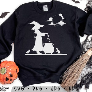 May include: Black sweatshirt featuring a white graphic of a witch stirring a cauldron, with a cat and bats. The design includes a moon and clouds, perfect for Halloween. The words "California Drmn Design" are at the bottom.