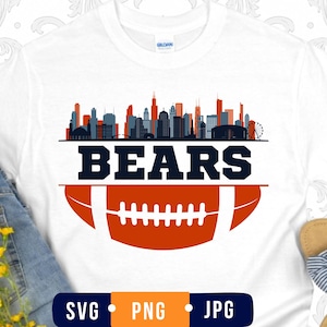 May include: A white t-shirt featuring a graphic print of a city skyline in shades of gray and orange above the word BEARS in dark blue letters, positioned over a stylized orange and white football graphic with the text SVG PNG JPG below.