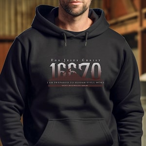 May include: Black hooded sweatshirt with a white graphic print that says "For Jesus Christ 16670 I am prepared to suffer still more Saint Maximilian Kolbe".