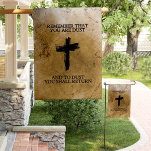 Könnte beinhalten: Zwei Gartenflaggen mit einem abgenutzten, Vintage-Look. Die größere Flagge zeigt ein schwarzes Kreuz und den Text "Denke daran, dass du Staub bist und zu Staub wirst du zurückkehren". Die kleinere Flagge ist ein Duplikat der größeren.