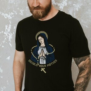 May include: Black t-shirt with a graphic of the Virgin Mary with a rosary and the text "Behold Your Mother".