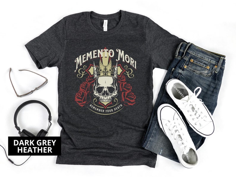 Pode incluir: Camiseta cinza escuro heather com um cr&acirc;nio usando uma coroa e as palavras "Memento Mori" e "Remember Your Death" impressas na frente.
