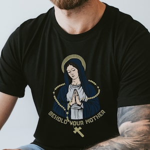 May include: Black t-shirt with a graphic of the Virgin Mary praying with a rosary and the text "Behold your mother".