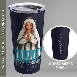 May include: Navy blue Catholic tumbler with a silver lid. The tumbler features an illustration of the Virgin Mary, the text "Lourdes Ave Maria 1858", and the words "Catholic Tumbler - Personalized". A separate image shows the words "Mary Elizabeth" and "Customized Name".