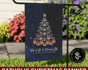 Può includere: Una bandiera da giardino natalizia blu con un albero di Natale dorato e regali. Il testo sulla bandiera recita "Il dono della vita eterna è il miglior dono mai ricevuto".