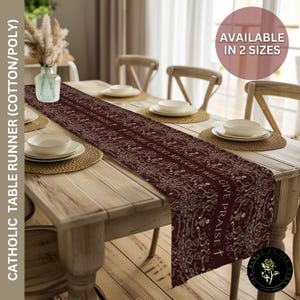 May include: A burgundy cotton/poly table runner with a repeating floral pattern and the text "I TO THEE O GOD MY GOD I WILL GIVE PRAISE". The runner is displayed on a wooden table set for a meal.